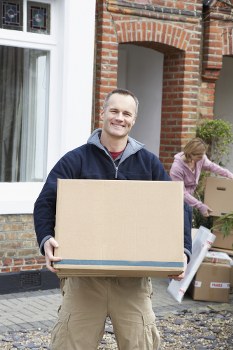 Man and a van loading household items into a vehicle