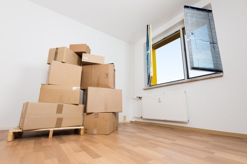 Professional movers handling a piano through a narrow stairway